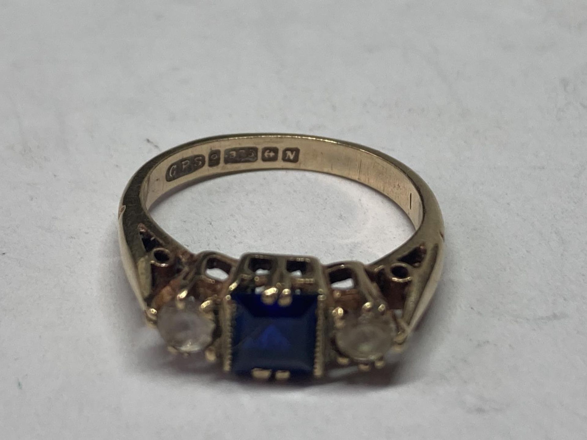 A 9 CARAT GOLD RING WITH CENTRE SAPPHIRE AND CUBIC ZIRCONIAS