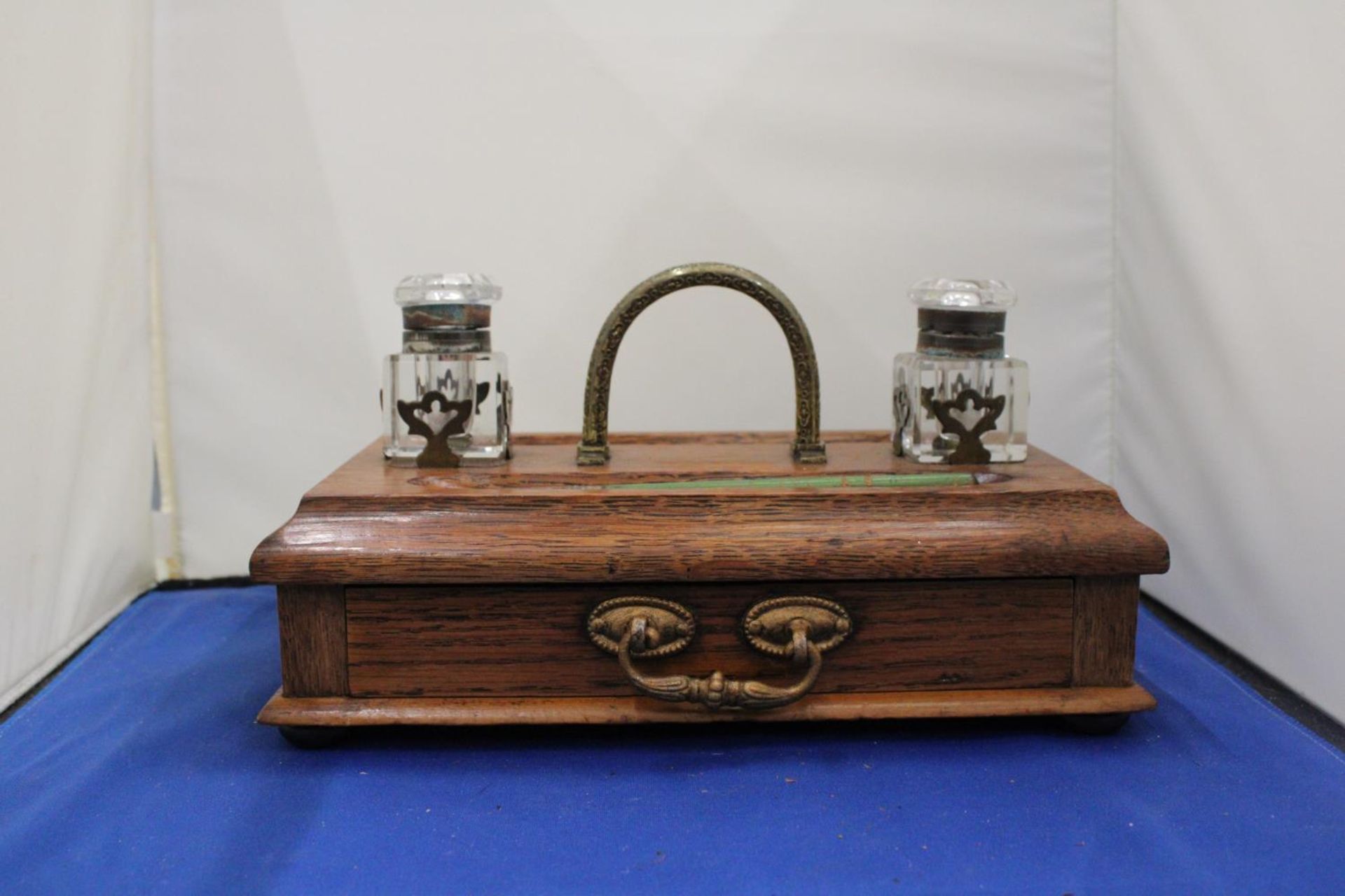 AN OAK INK WELL DESK SET WITH TWO GLASS BOTTLES, PEN AND DRAWER