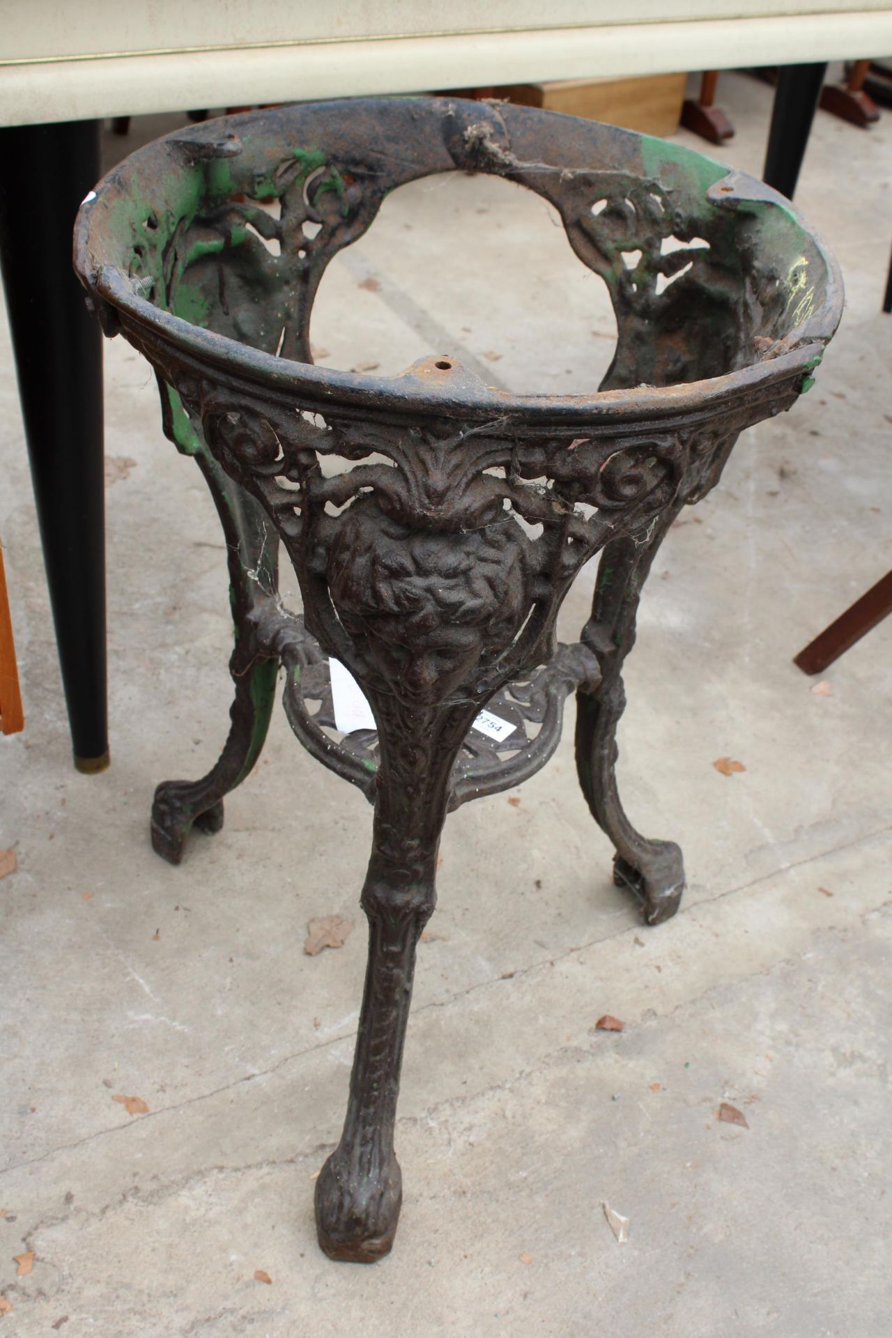 A CAST IRON PUB TABLE BASE WITH MASK AND FOLIATE DECORATION