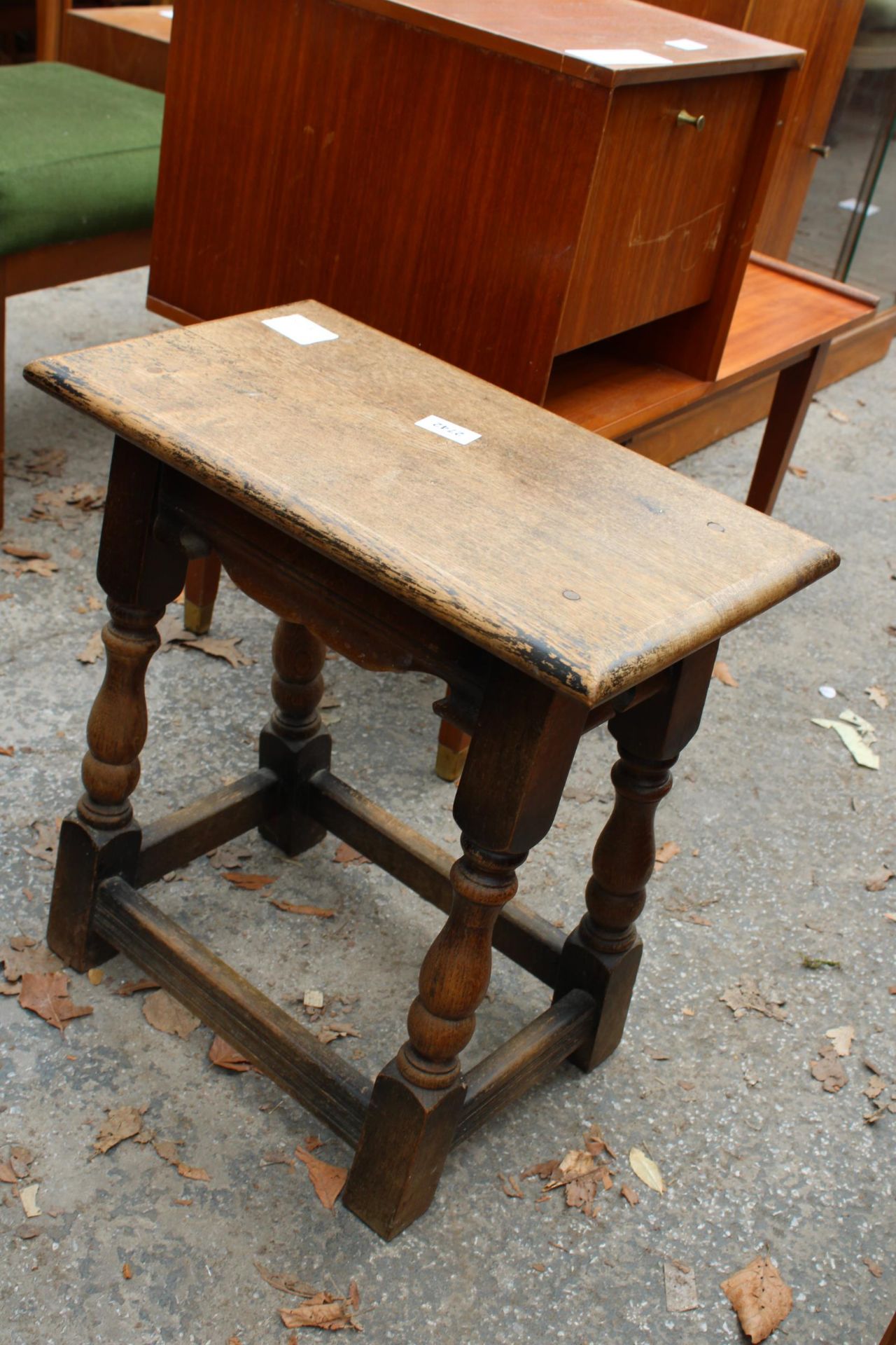 AN OAK JACOBEAN STYLE STOOL ON TURNED LEGS