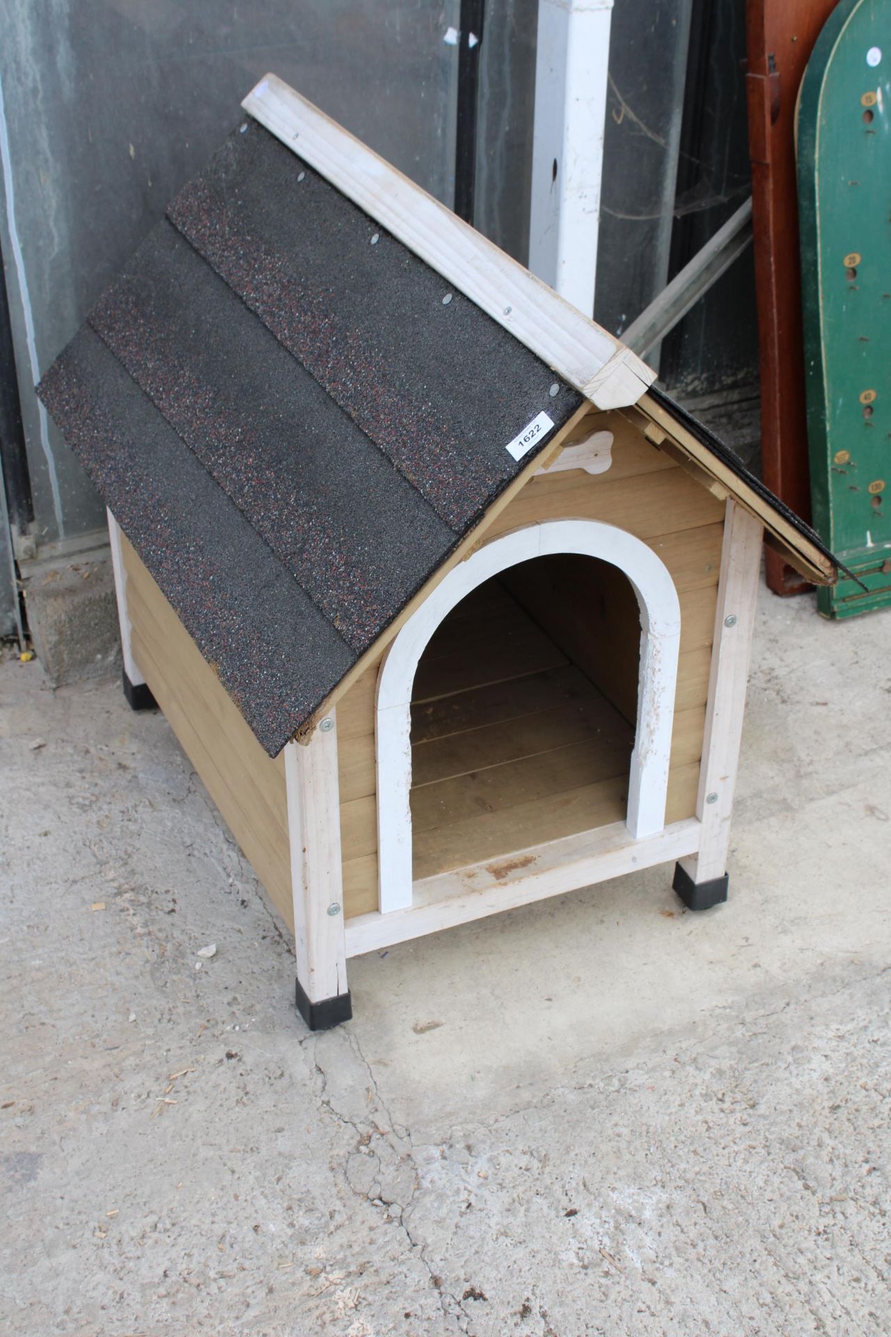 A SMALL WOODEN DOG KENNEL WITH FELT ROOF