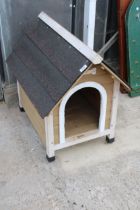 A SMALL WOODEN DOG KENNEL WITH FELT ROOF
