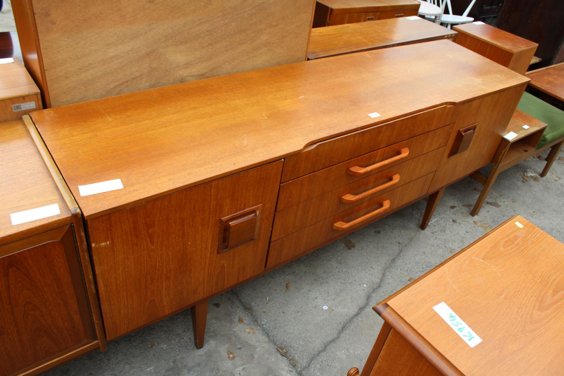 A TEAK BEAUTILITY SIDEBOARD ENCLOSING FOUR DRAERS AND TWO CUPBOARDS, 72" WIDE