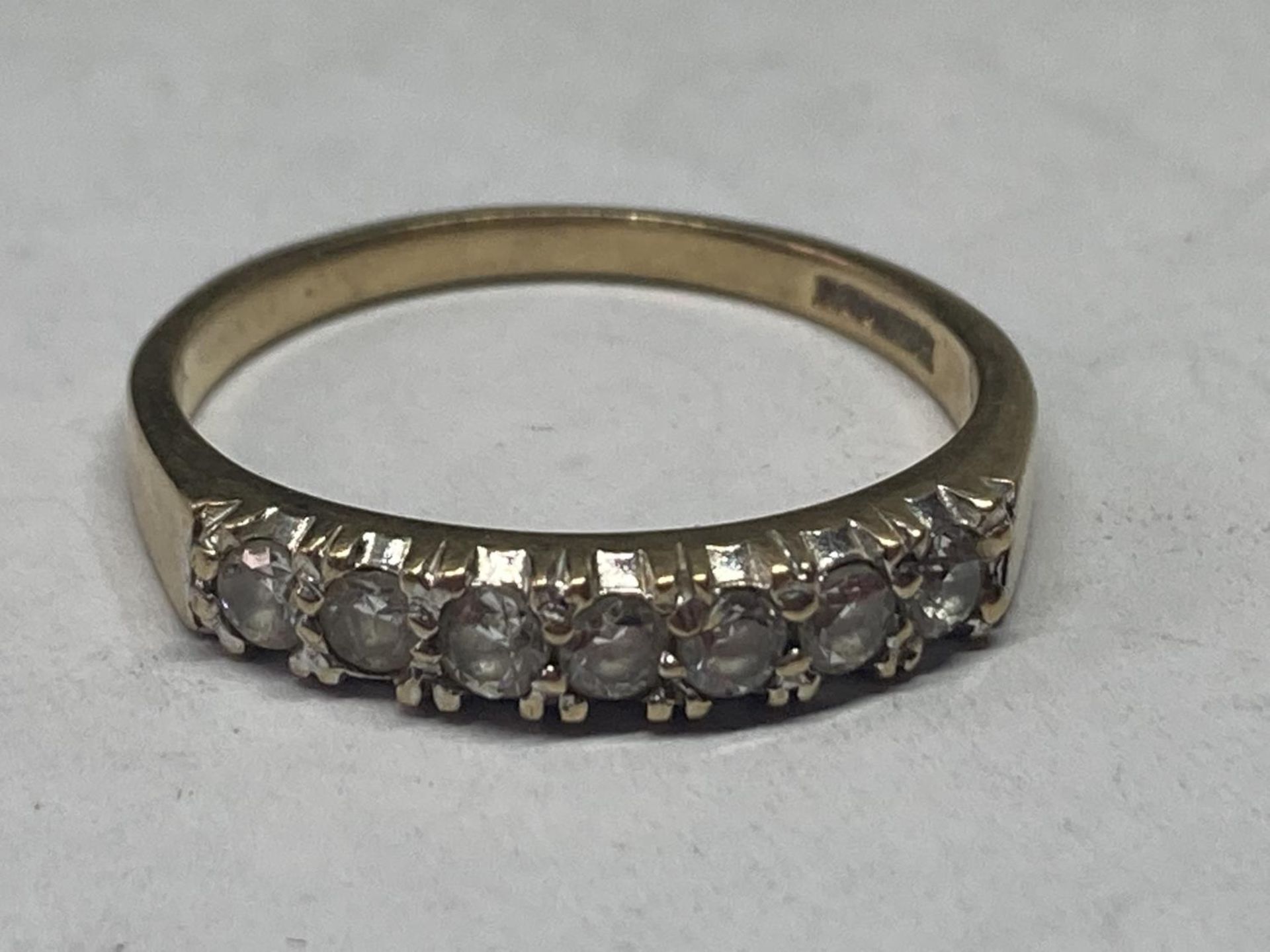 A 9 CARAT GOLD RING WITH SEVEN IN LINE CUBIC ZIRCONIAS SIZE Q/R