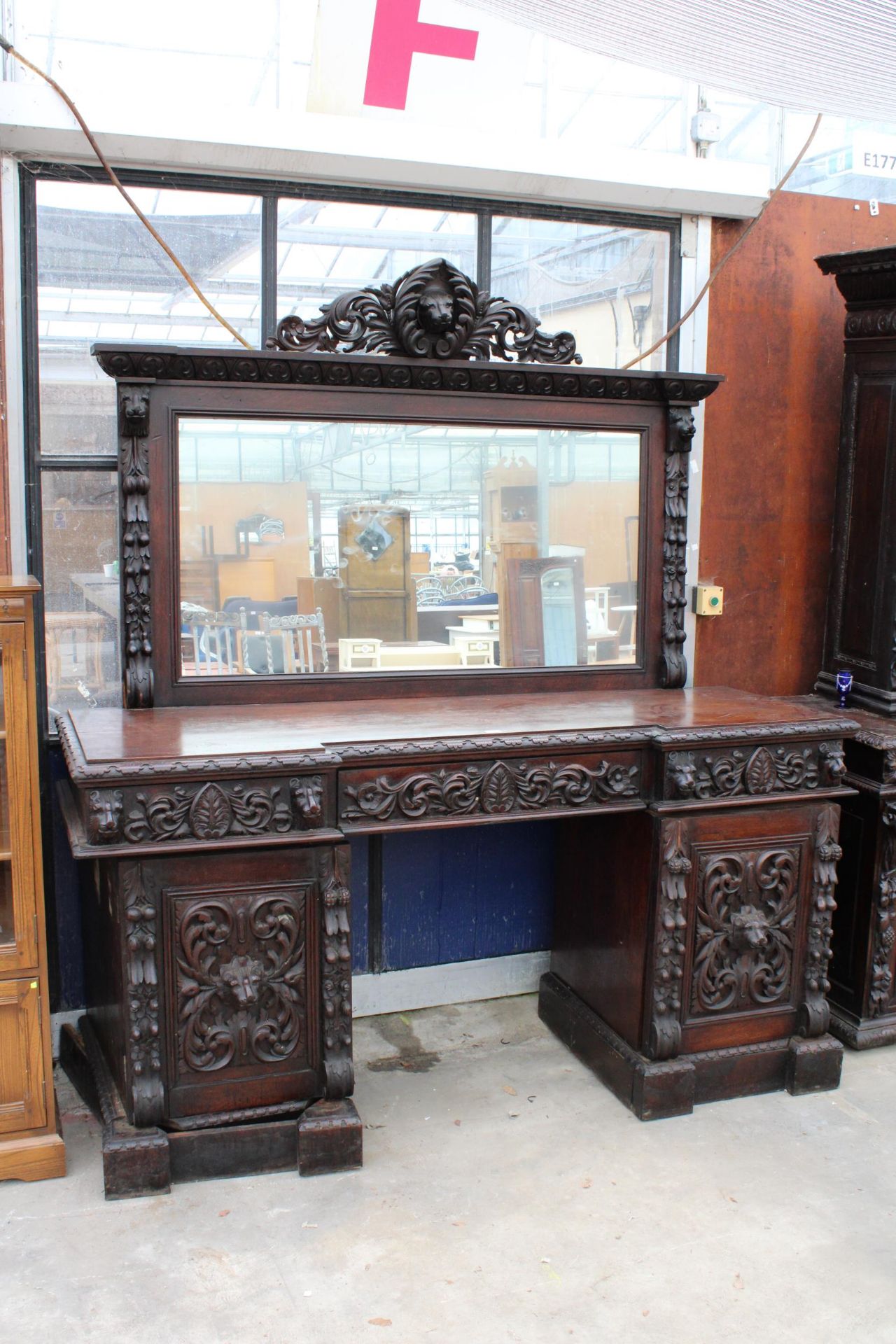 A VICTORIAN OAK BLACK FOREST STYLE MIRROR BACK SIDEBOARD HEAVILY CARVED WITH LION MASK HEAD AND