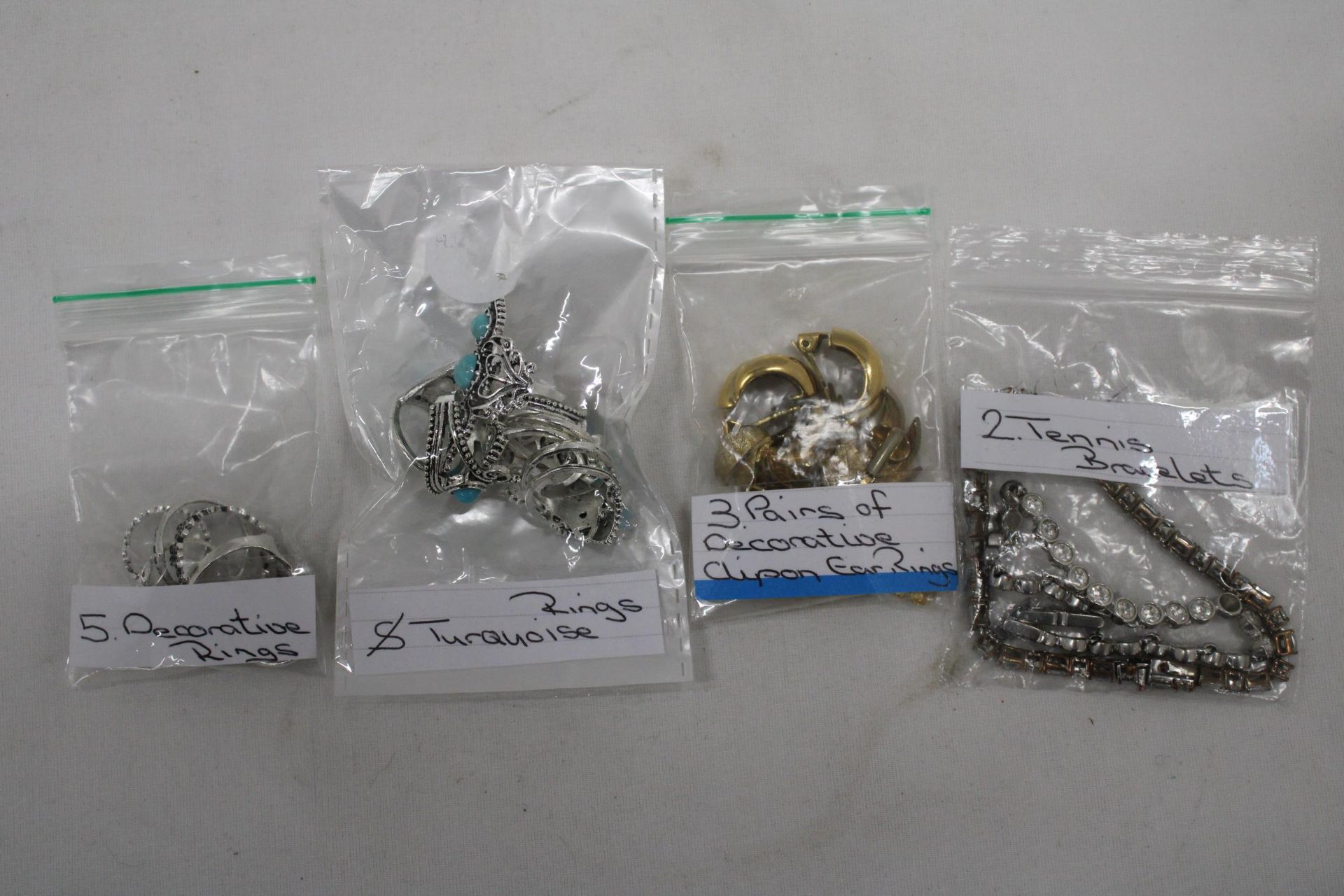 A QUANTITY OF COSTUME JEWELLERY TO INCLUDE TURQUOISE RINGS, CLIP ON EARRINGS AND TENNIS BRACELETS