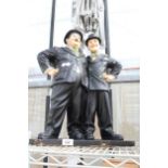 A LARGE PLASTIC FIGURE OF LAUREL AND HARDY (A/F TO THE BACK)