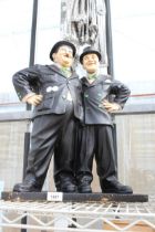 A LARGE PLASTIC FIGURE OF LAUREL AND HARDY (A/F TO THE BACK)