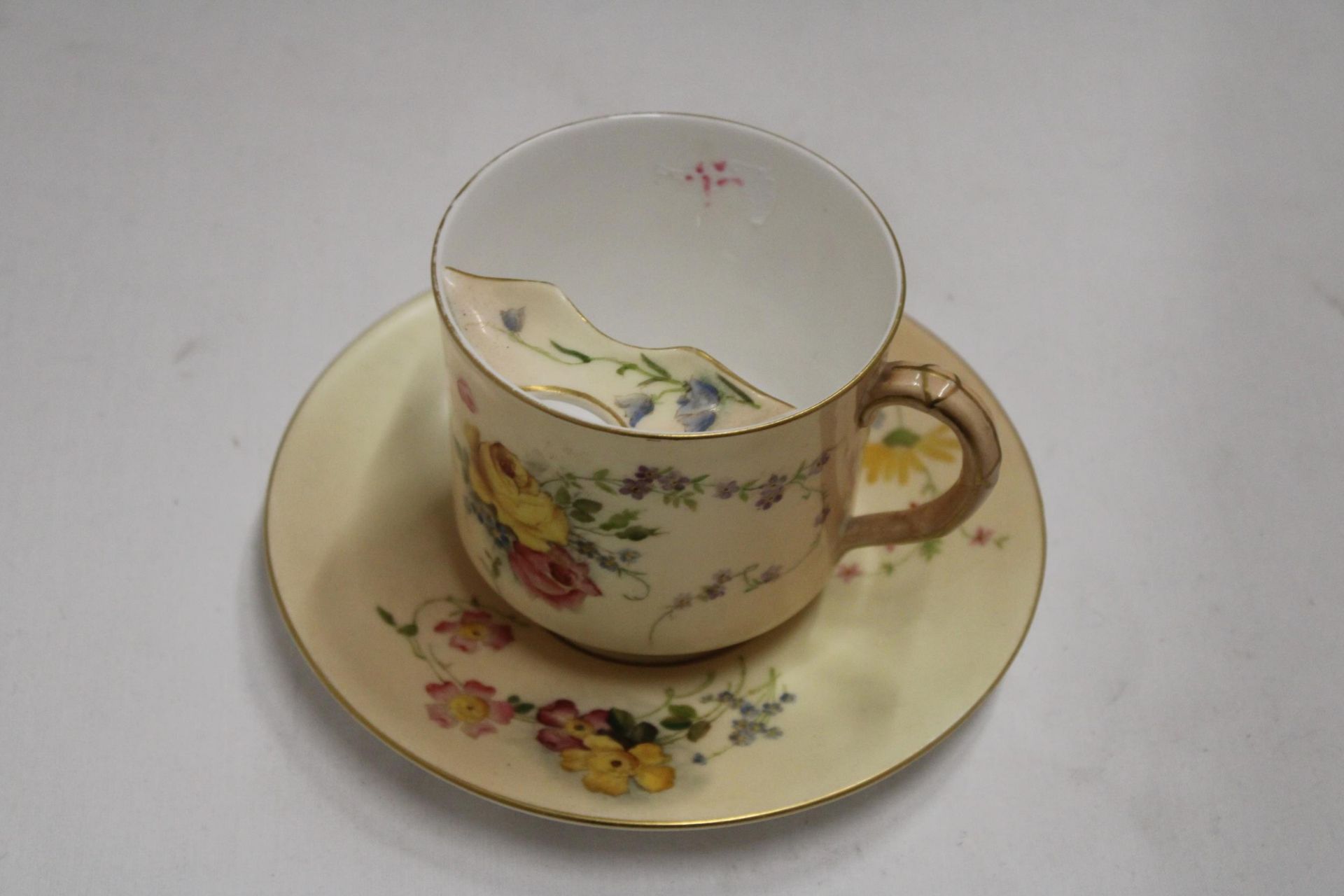 A ROYAL WORCESTER BLUSH IVORY MOUSTACHE CUP AND SAUCER