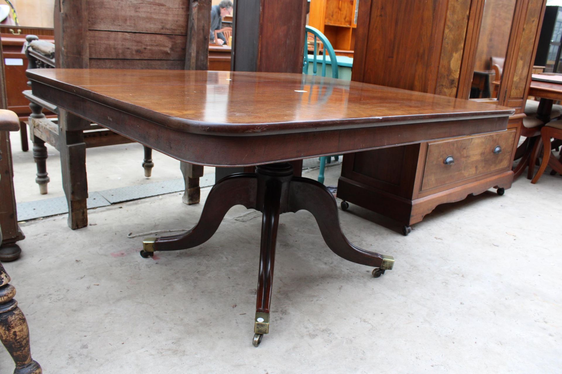 A REGENCY STYLE MAHOGANY PEDESTAL TILT-TOP DINING TABLE 56" X 46.5" WITH BRASS FEET AND CASTERS - Image 2 of 3