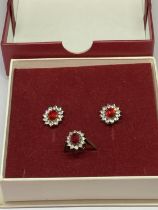 A SILVER RED STONE RING AND EARRINGS IN A PRESENTATION BOX