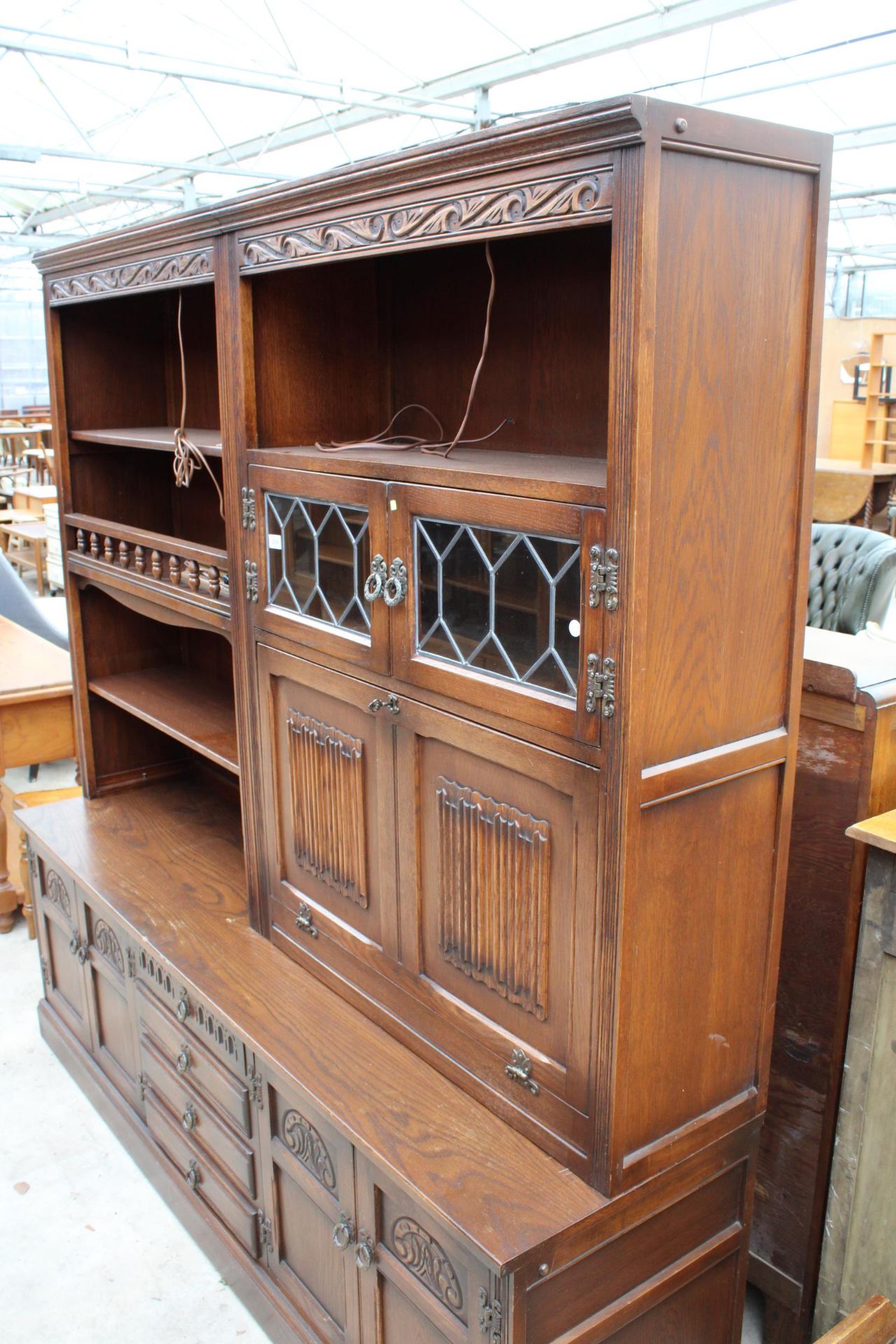 AN OAK OLD CHARM LOUNGE UNIT WITH GLAZED AND LEADED LINEN FOLD DOORS WITH CUPBOARDS AND DRAWERS TO - Bild 2 aus 4