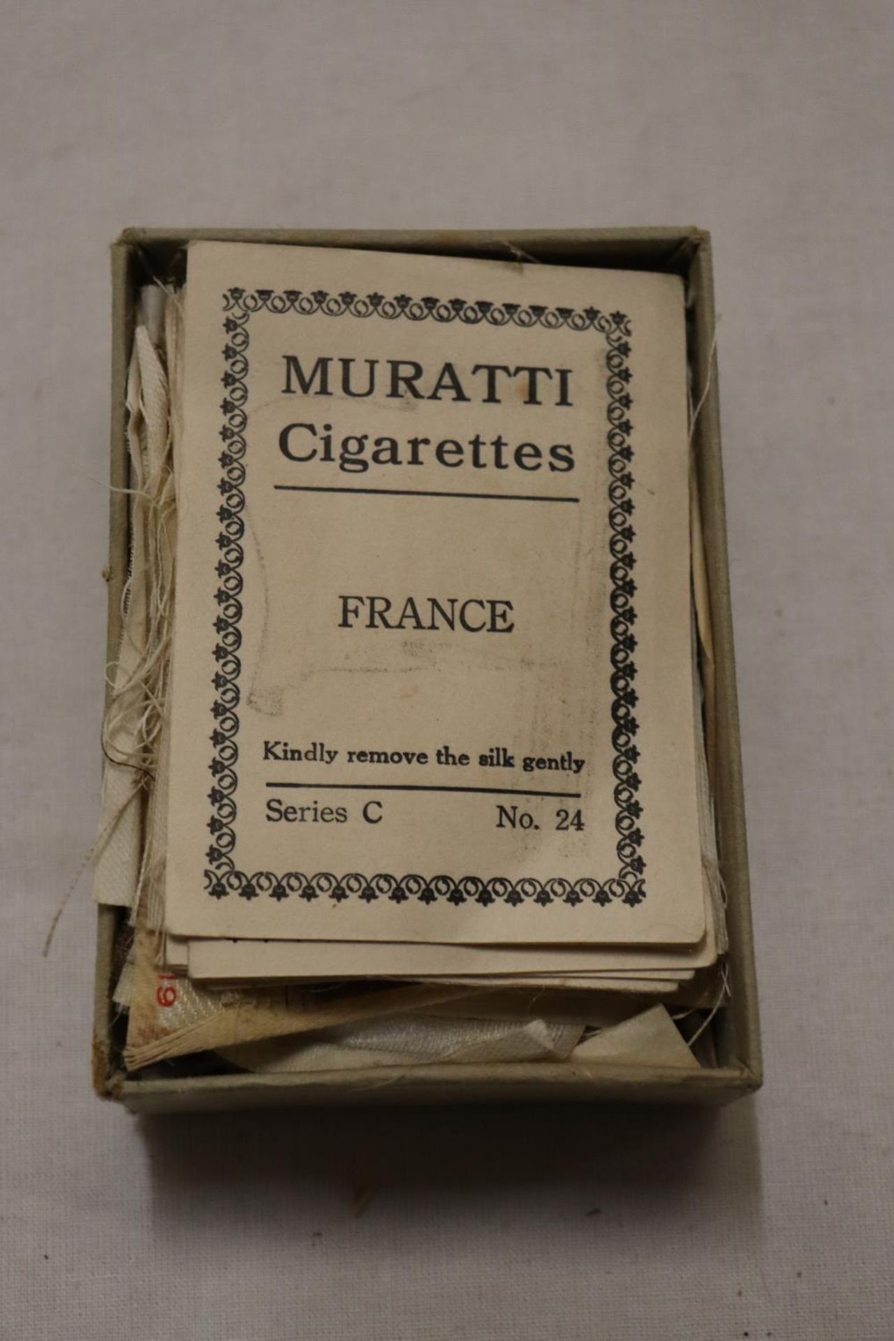 A BOX OF MURATTI CIGARETTES SILK CARDS CIRCA 1914, THE SILKS BEING FLAGS OF THE WORLD