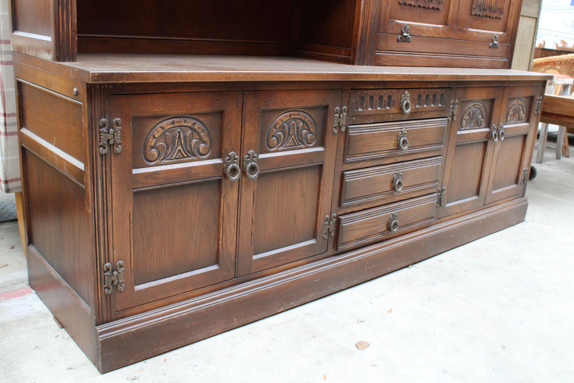 AN OAK OLD CHARM LOUNGE UNIT WITH GLAZED AND LEADED LINEN FOLD DOORS WITH CUPBOARDS AND DRAWERS TO - Image 3 of 4