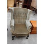 A GEORGION STYLE WINGED BUTTON-BACK EASY CHAIR ON FRONT CABRIOLE LEGS WITH CARVED KNEES ON BALL