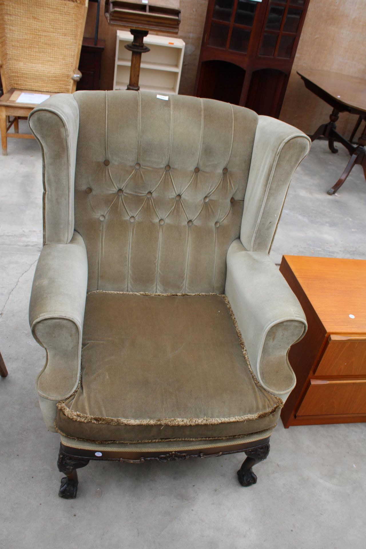 A GEORGION STYLE WINGED BUTTON-BACK EASY CHAIR ON FRONT CABRIOLE LEGS WITH CARVED KNEES ON BALL