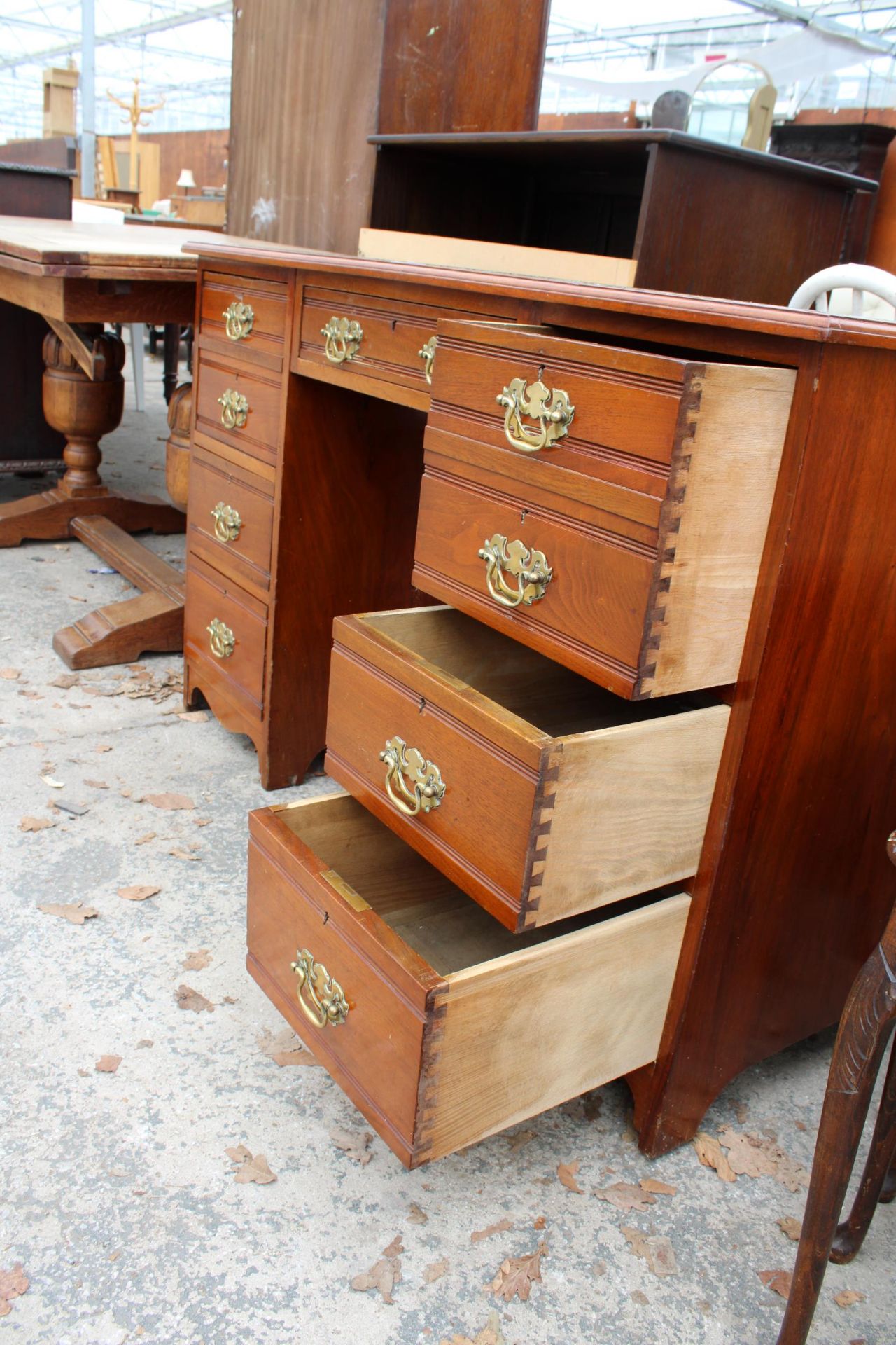 AN EDWARDIAN MAHOGANY KNEE HOLE DESK ENCLOSING SEVEN DRAWERS WITH BRASS HANDLES AND INSET LEATHER - Image 3 of 5