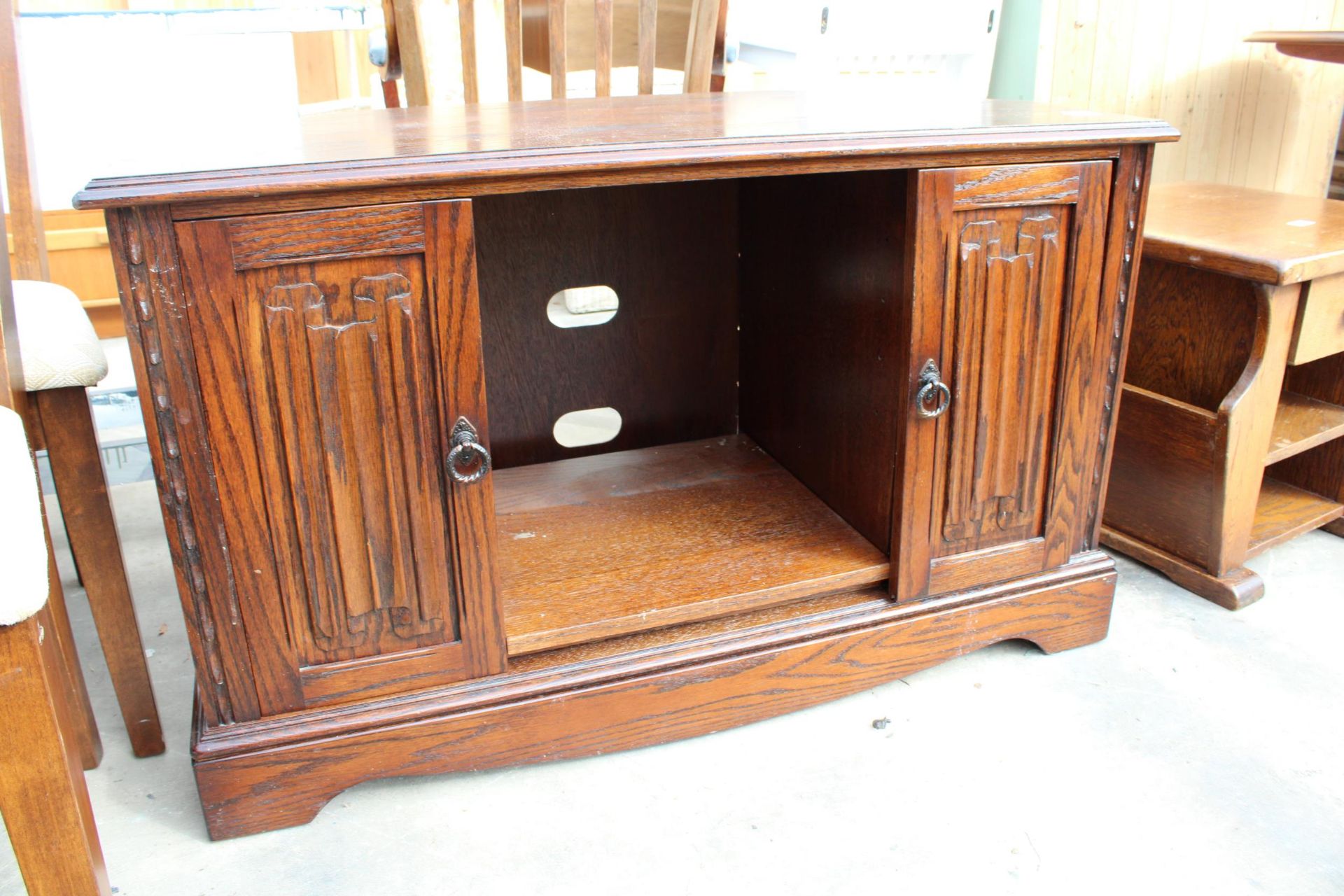 AN OAK MAGAZINE RACK / TABLE AND OAK JAYCEE TELEVISION STAND WITH LINENFOLD SLIDING DOORS - Image 5 of 5