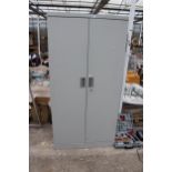 A METAL TWO DOOR WORKSHOP STORAGE CUPBOARD