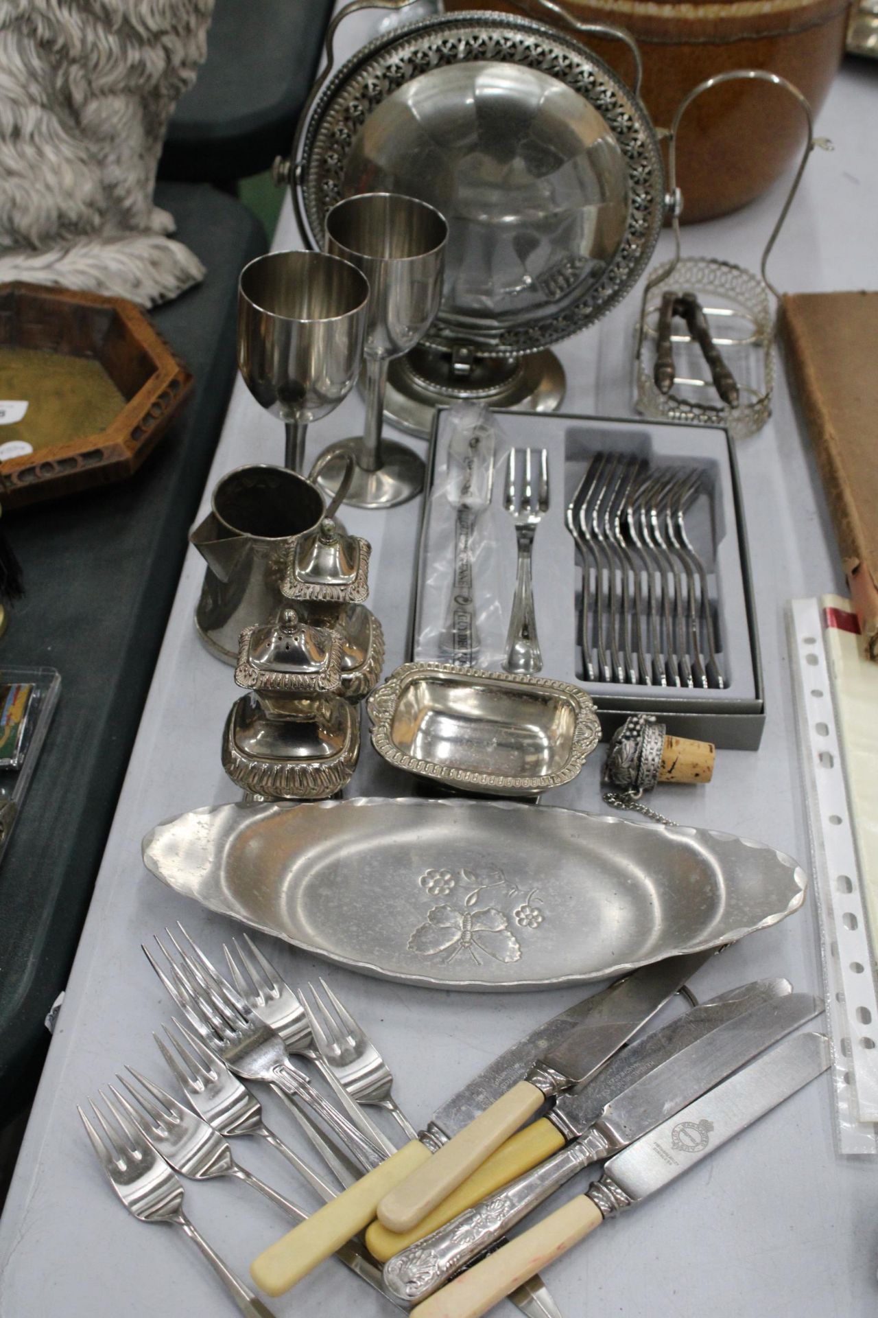 A QUANTITY OF SILVER PLATED AND METAL ITEMS TO INCLUDE GOBLETS, A CRUET SET, DISHES, FLATWARE, ETC