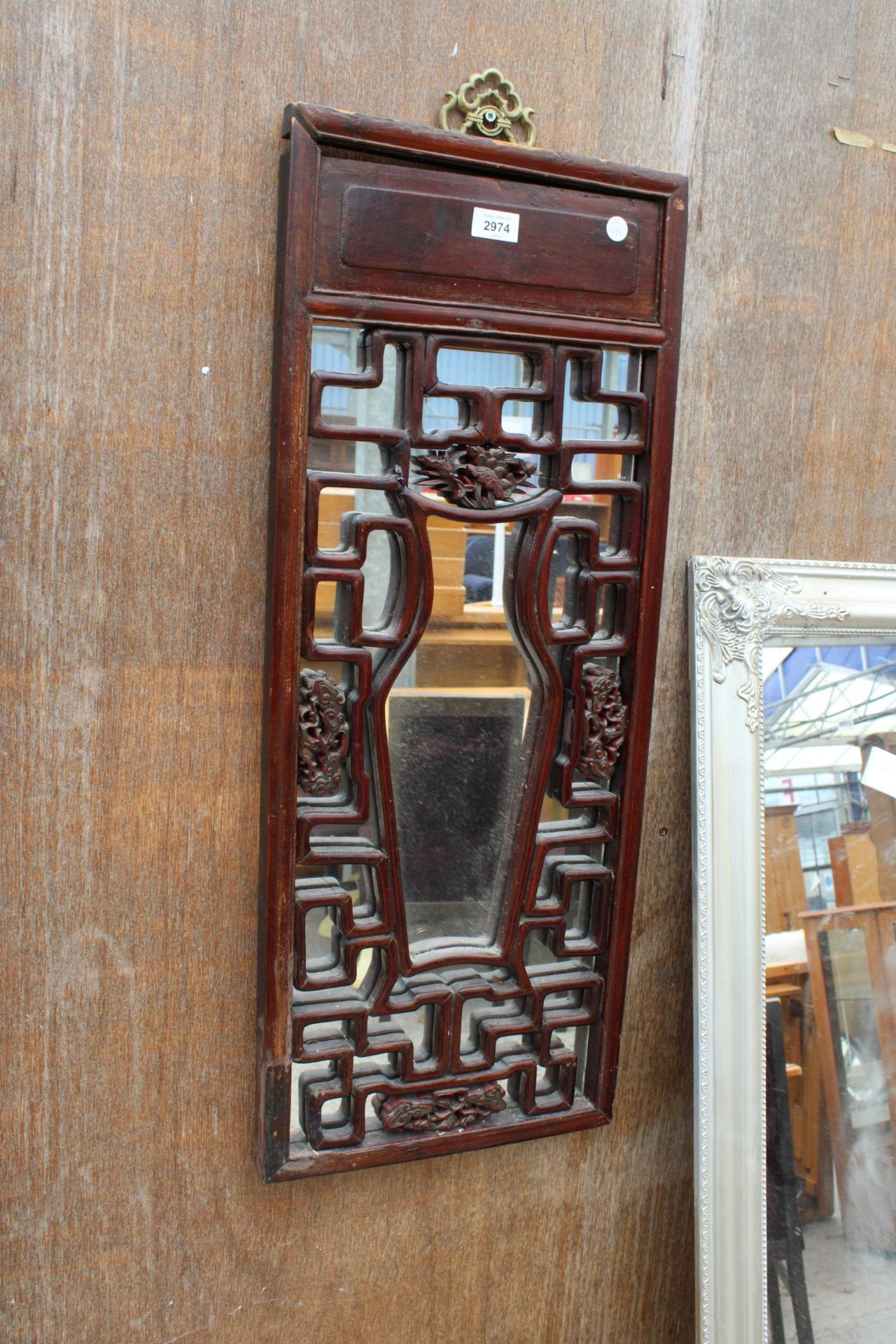 AN ORIENTAL HARDWOOD CARVED AND MIRRORED PANEL 33" X 13"