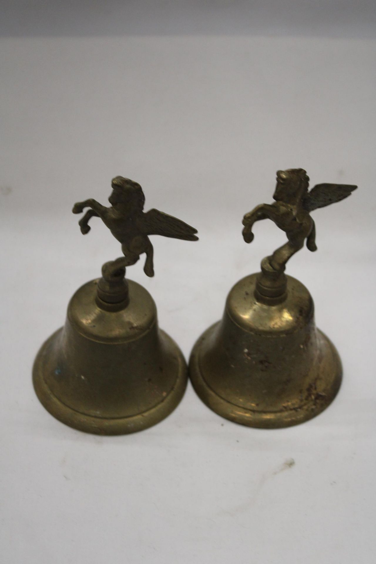 TWO BRASS 'PEGASUS' BELLS, HEIGHT 17CM