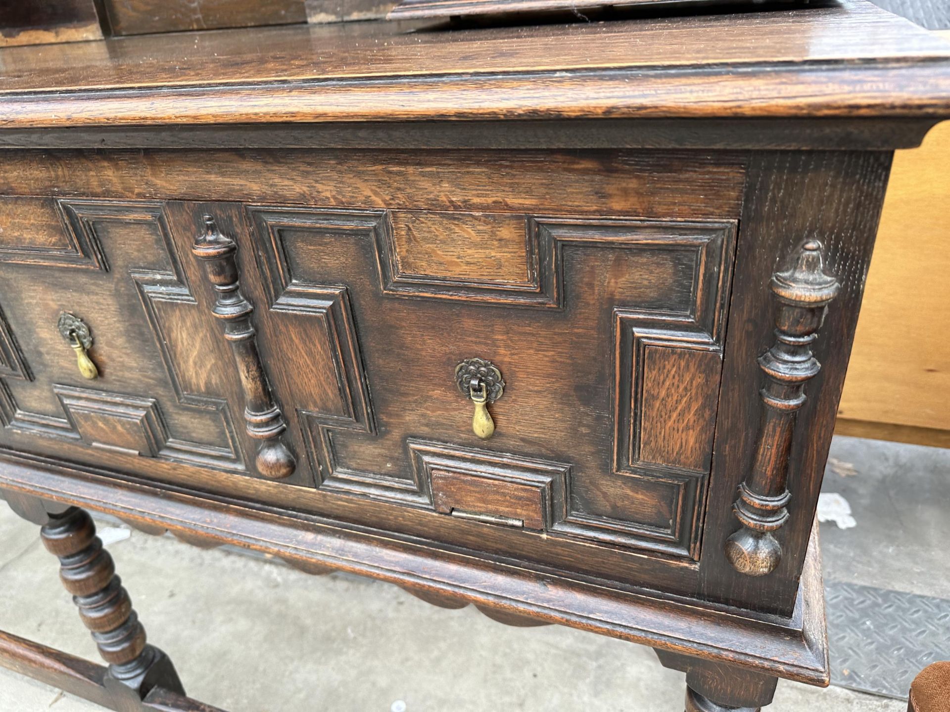 AN OAK JACOBEAN STYLE DRESSER WITH TWO FOLD-D0WN COMPARTMENTS AND A PLATE RACK ENCLOSING CUPBOARD - Image 5 of 7