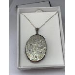 A SILVER OVAL LOCKET IN A PRESENTATION BOX