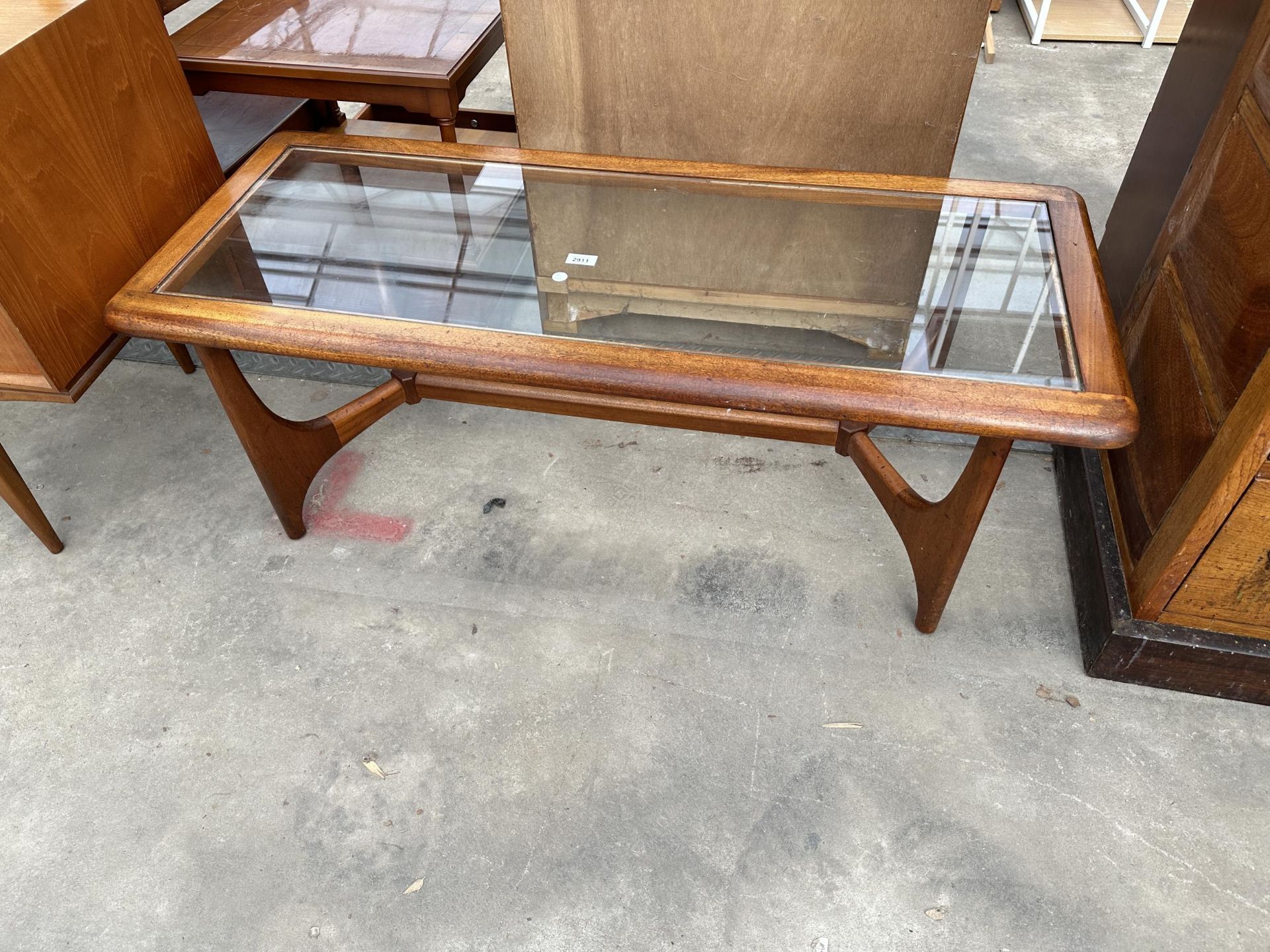 A RETRO TEAK COFFEE TABLE WITH GLASS TOP ON CHEVRON LEGS AND STRAIGHT STRETCHER, 47" X 20"