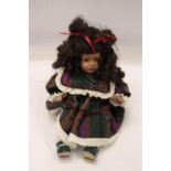 A VINTAGE CHINA DOLL IN SEATED POSE