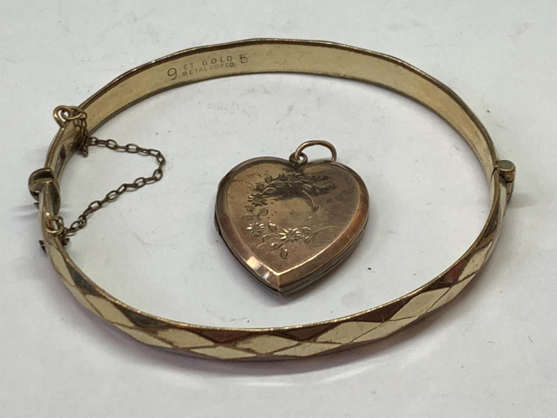 TWO 9 CARAT GOLD PLATED ITEMS - A BANGLE AND A HEART SHAPED LOCKET - Image 2 of 3