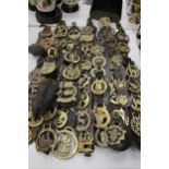 A LARGE COLLECTION OF HORSE BRASSES ON LEATHER STRAPS