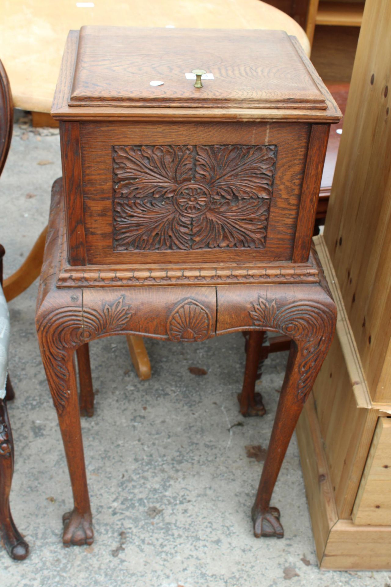 A VICTORIAN OAK CABINET ON STAND WITH CARVED FLORAL PANELS ON CABRIOLE LEGS WITH CLAW FEET