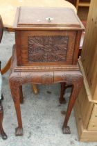 A VICTORIAN OAK CABINET ON STAND WITH CARVED FLORAL PANELS ON CABRIOLE LEGS WITH CLAW FEET