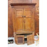 A 19TH CENTURY PINE FULL LENGTH FOUR DOOR CORNER CUPBOARD WITH SHAPED INTERIOR SHELVES TO UPPER