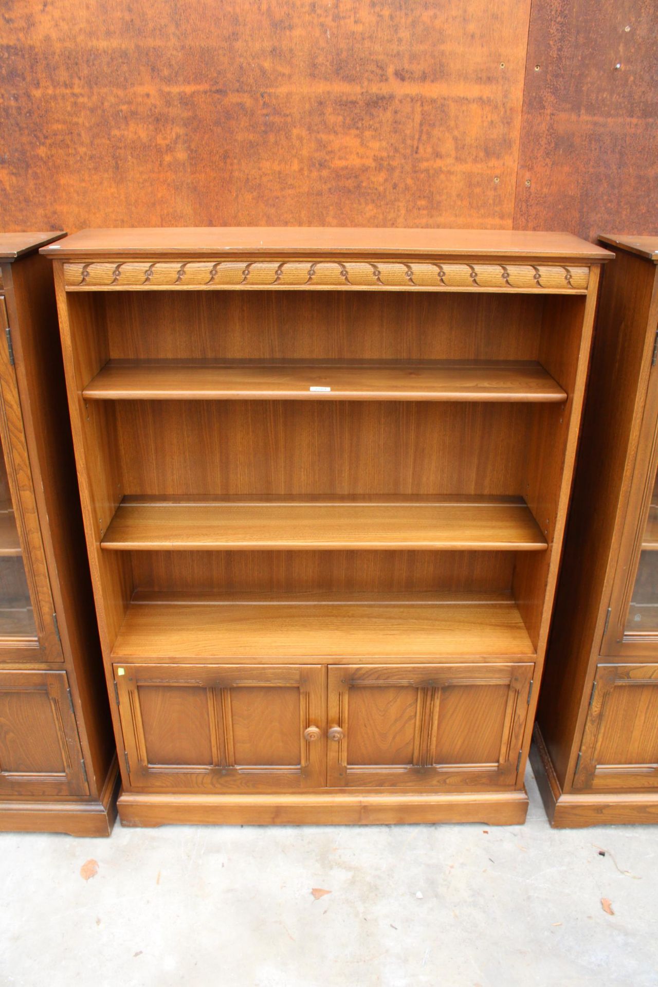 AN ERCOL BLONDE THREE TIER OPEN BOOKCASE WITH CUPBOARD TO BASE 39.5" WIDE