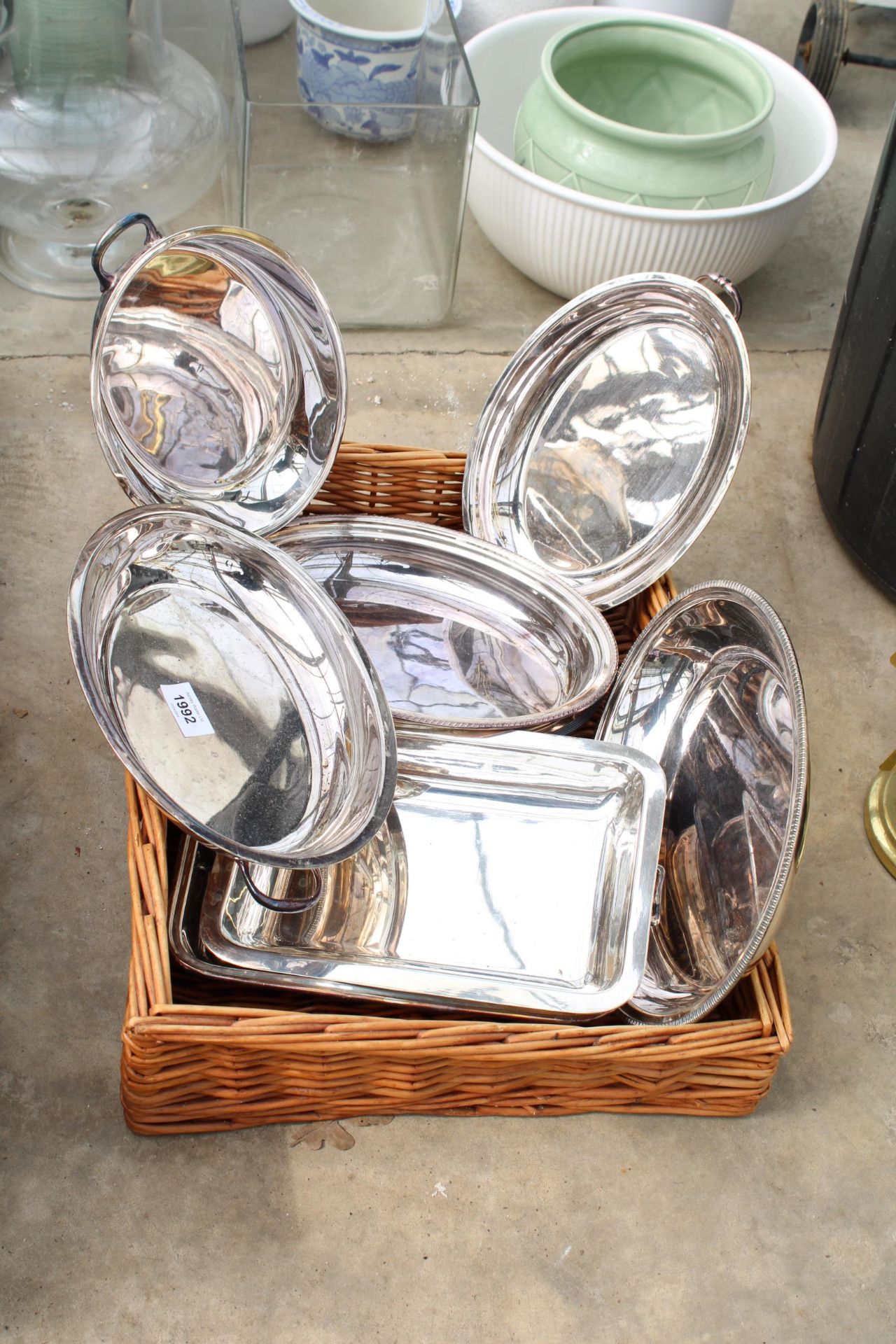 A WICKER TRAY AND AN ASSORTMENT OF SILVER PLATED SERVING TRAYS