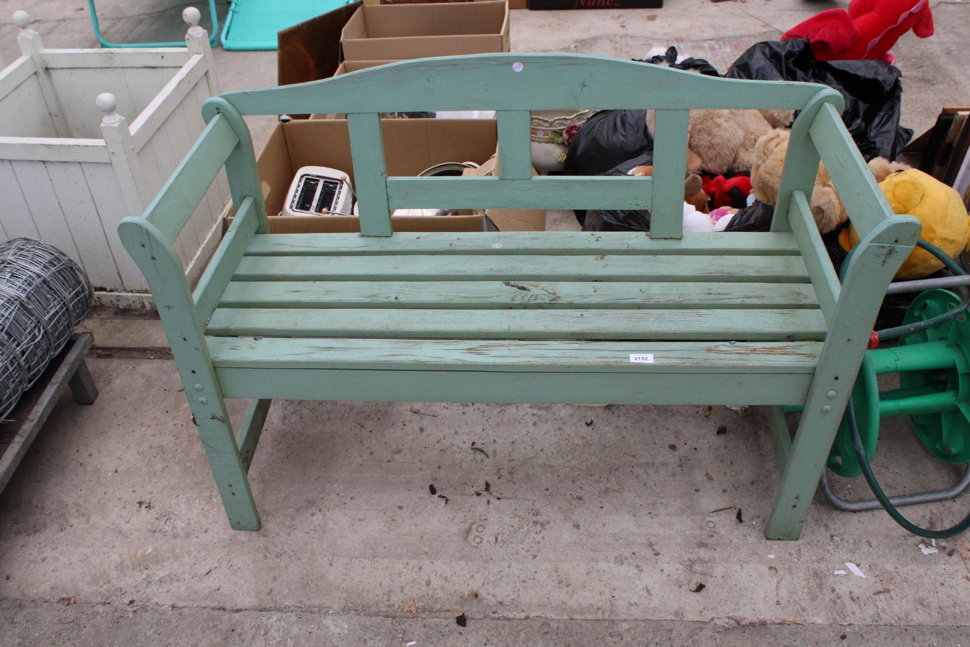 A WOODEN SLATTED GARDEN BENCH