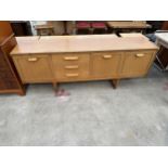 A RETRO TEAK SIDEBOARD ENCLOSING THREE DRAWERS AND THREE CUPBOARDS, 72" WIDE