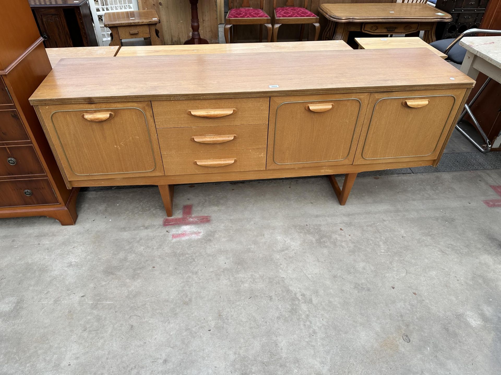 A RETRO TEAK SIDEBOARD ENCLOSING THREE DRAWERS AND THREE CUPBOARDS, 72" WIDE