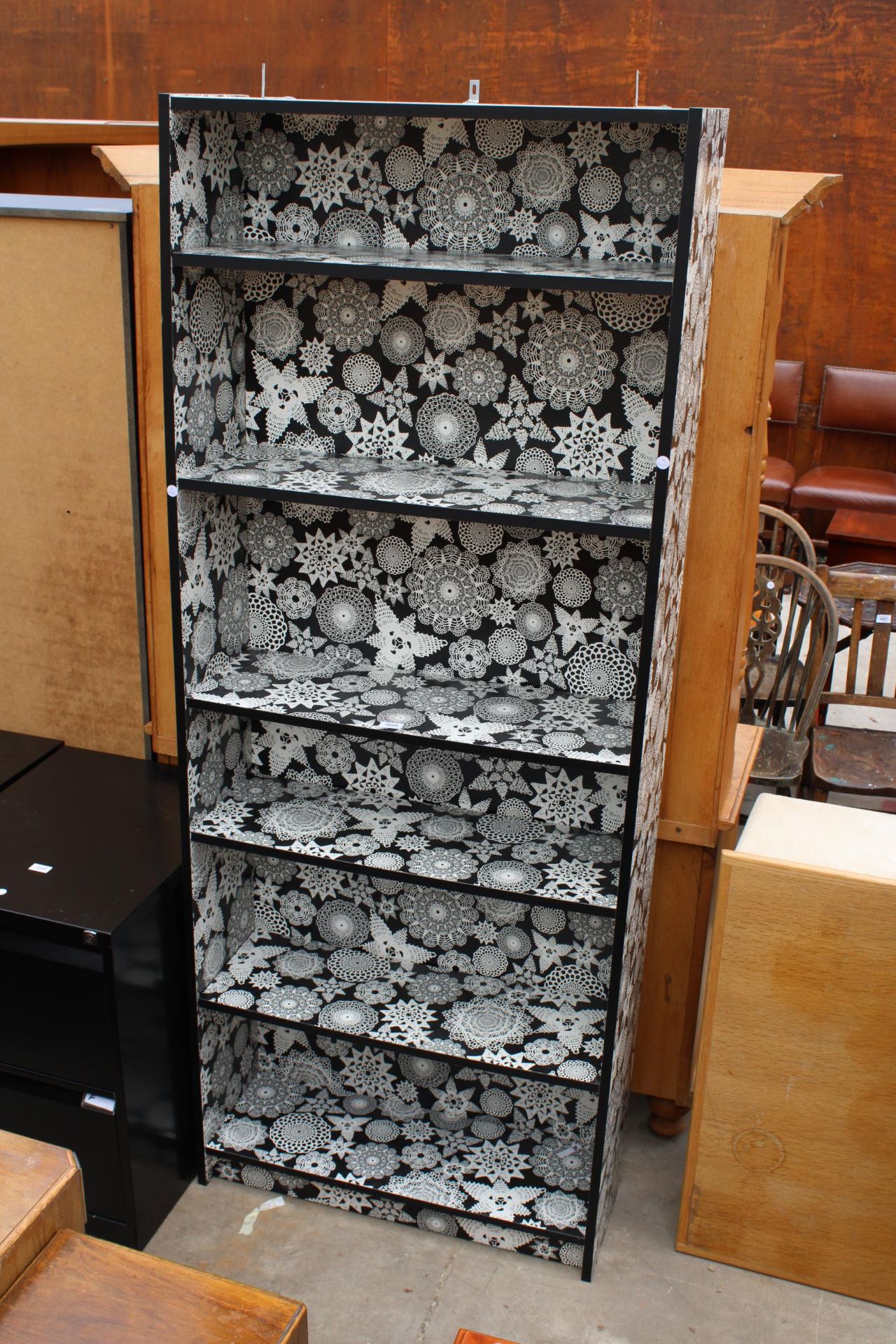 A MODERN SIX TIER OPEN BOOKSHELF WITH BLACK AND WHITE DECORATION DEPICTING DOILIES, 31.5" WIDE