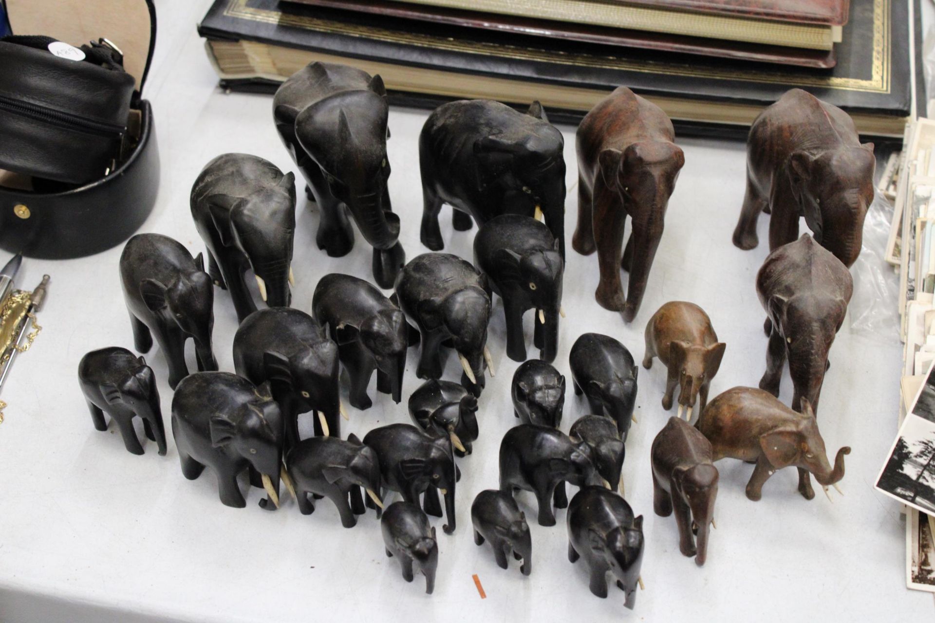 A LARGE COLLECTION OF VARIOUS SIZES OF WOODEN ASIAN ELEPHANTS