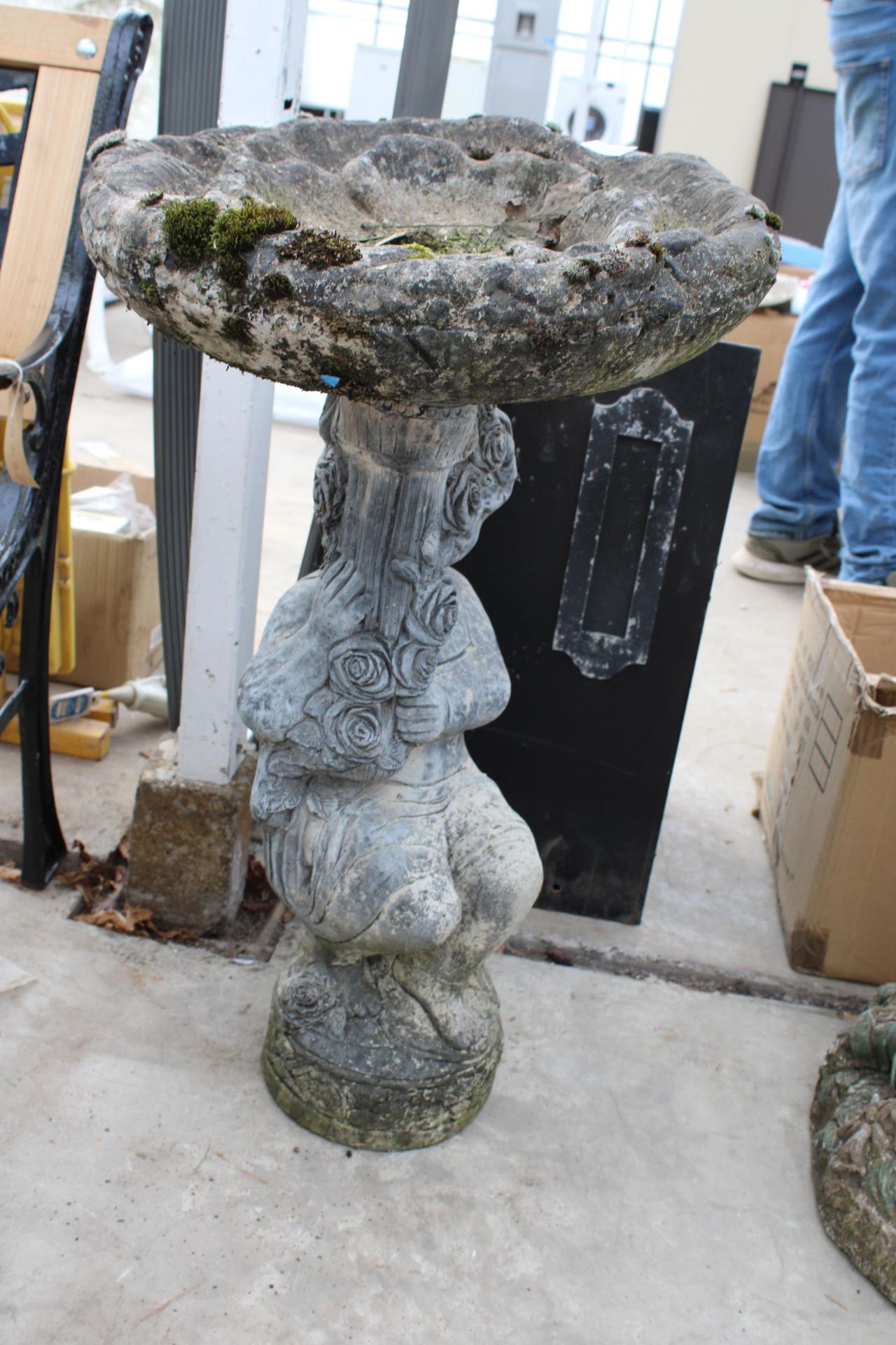 A CONCRETE GARDEN BIRDBATH WITH CHERUB PEDESTAL BASE