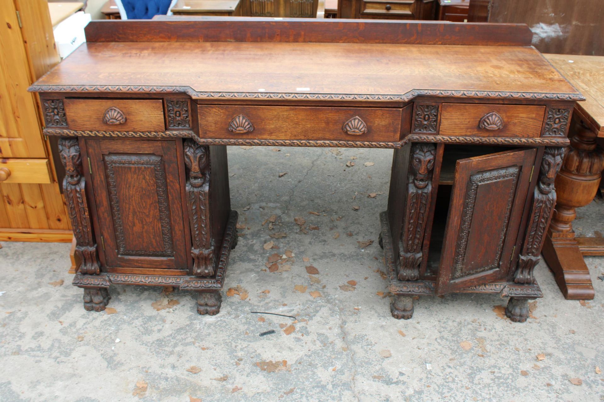 A VICTORIAN OAK BREAKFRONT SIDEBOARD ON CARVED CLAW FEET WITH CARVED PANELS WITH MYTHICAL