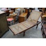 A LATE VICTORIAN HARDWOOD FOLDING DAY BED ON TURNED LEGS WITH SPLIT CANE SEATS/BACK