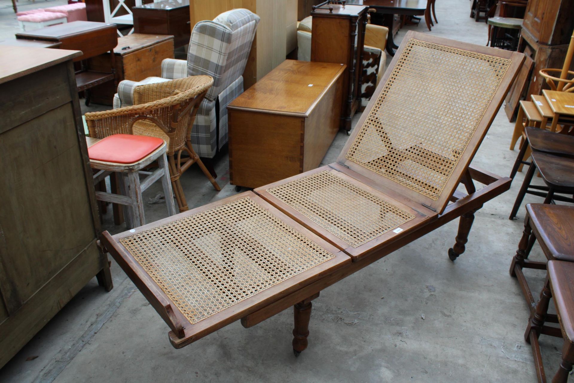 A LATE VICTORIAN HARDWOOD FOLDING DAY BED ON TURNED LEGS WITH SPLIT CANE SEATS/BACK