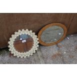 A MODERN METAL FRAMED WALL MIRROR 13" DIAMETER WITH PETAL DECORATION AND AN OVAL POKER WORK STYLE