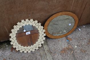 A MODERN METAL FRAMED WALL MIRROR 13" DIAMETER WITH PETAL DECORATION AND AN OVAL POKER WORK STYLE