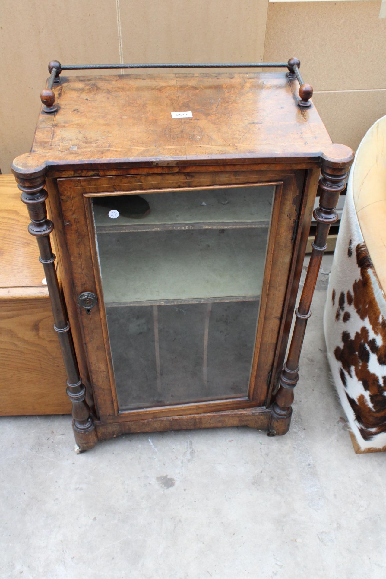 A VICTORIAN WALNUT MUSIC CABINET WITH GLASS DOOR, TURNED UPRIGHTS AND GALLERY BACK 23" WIDE