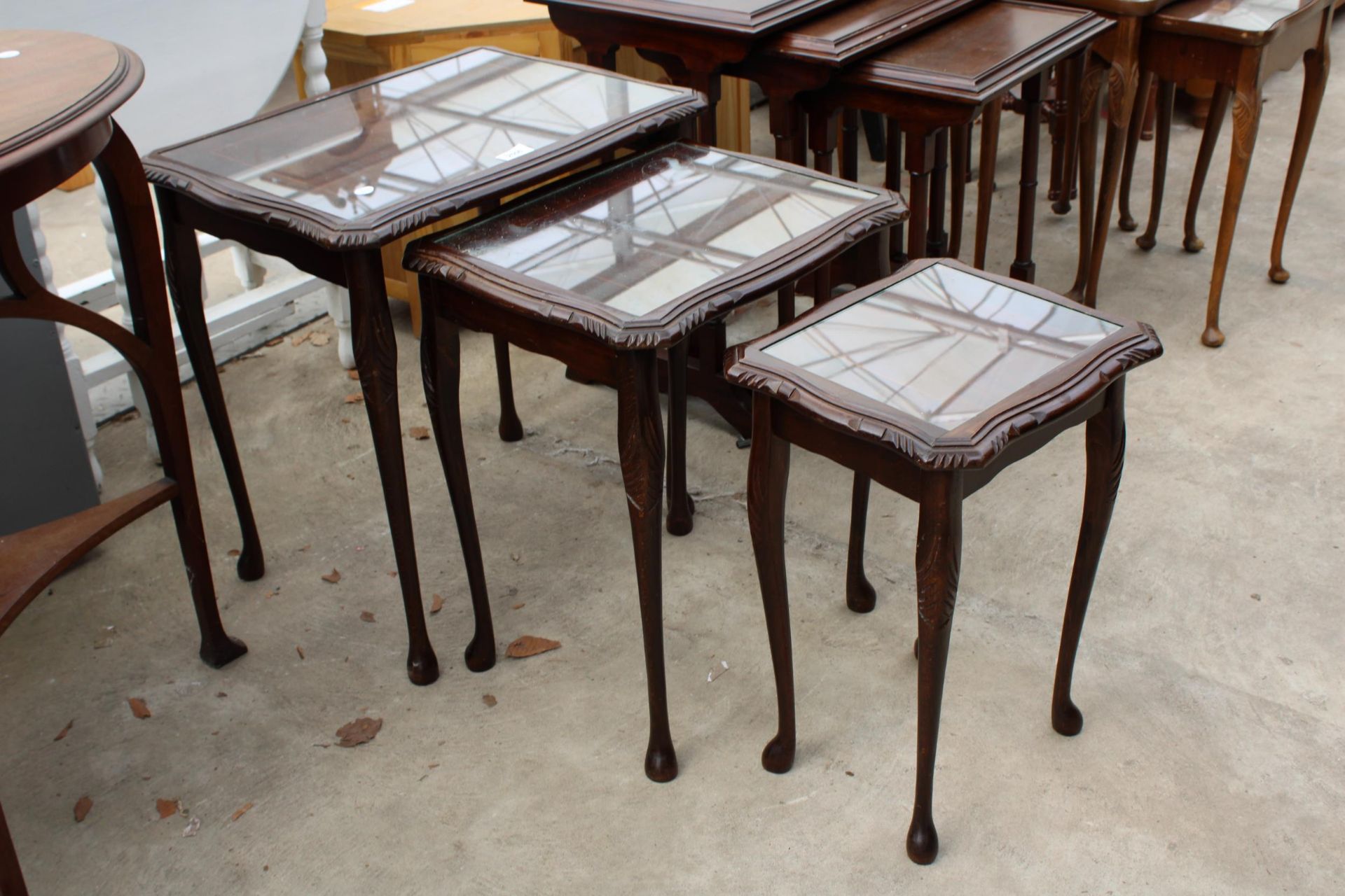 A MAHOGANY NEST OF THREE TABLES ON CABRIOLE LEGS